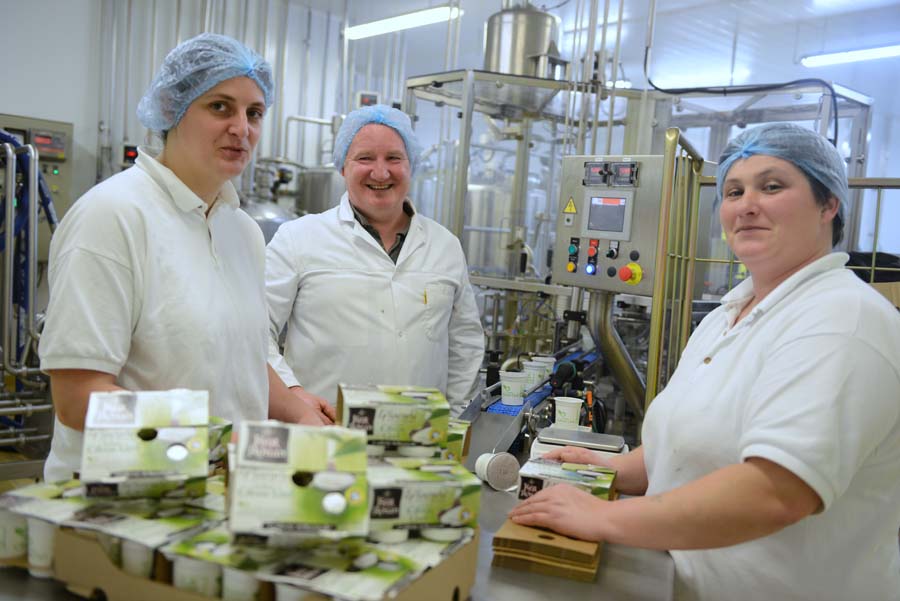 Nous voyons trois salarié qui se trouve dans la laiterie Ker Ronan présentant des yaourts